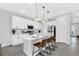 Modern white kitchen with stainless steel appliances, a large center island, and stylish pendant lighting at 730 Longboat Dr, Davenport, FL 33896