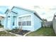 Attractive one-story home with a light blue exterior, framed by green lawn and clean landscaping at 743 Belvoir Dr, Davenport, FL 33837