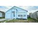 Inviting one-story home with a light blue exterior and a well-kept front yard and single car garage at 743 Belvoir Dr, Davenport, FL 33837