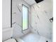 Contemporary shower featuring black fixtures, white marble tiling, and white penny tile floors at 758 Osceola Dr, Sanford, FL 32773