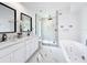 Stylish bathroom featuring a jacuzzi tub, double vanity, marble countertops, and a glass-enclosed shower at 758 Osceola Dr, Sanford, FL 32773