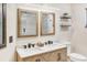 Bathroom featuring double sink vanity, wood grain cabinets and framed mirrors at 811 Gatehouse Dr, Winter Springs, FL 32708