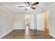 Light-filled bedroom showcasing hardwood floors, neutral walls, a ceiling fan, and two doorways at 811 Gatehouse Dr, Winter Springs, FL 32708