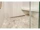 Modern shower with stylish hexagonal floor tiles, a built-in bench, and sleek glass doors at 811 Gatehouse Dr, Winter Springs, FL 32708