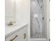 Modern bathroom boasts a walk-in shower with marble-style tile and pebble floor, plus vanity with sleek fixtures at 833 S Hancock Dr, Deltona, FL 32725