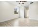 Bright bedroom features wood floors, a ceiling fan, and a view into the bathroom at 833 S Hancock Dr, Deltona, FL 32725