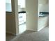 Small kitchen with black countertops and white appliances, adjacent to a carpeted living space at 860 N Orange Ave # 444, Orlando, FL 32801