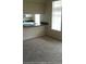 Carpeted living room showing a serving hatch to a kitchen and window at 860 N Orange Ave # 444, Orlando, FL 32801