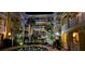 Nighttime view of an outdoor community pool area with palm trees and balconies on the building's many levels at 860 N Orange Ave # 444, Orlando, FL 32801