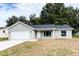 Newly renovated single-story home featuring a fresh gray exterior, a two-car garage, and a well-manicured front yard at 1 Pine Radial Trl, Ocala, FL 34472