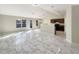 Bright living room featuring elegant tile flooring, high ceilings, and an open layout connected to the kitchen at 1004 Puget Ln, Kissimmee, FL 34759