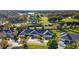 An aerial view of homes next to a golf course and a small lake in a sunny and green community at 1024 Green Gate Blvd, Groveland, FL 34736