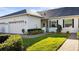 A well-maintained home with a two car garage, green grass, landscaping, and a paved walkway at 1024 Green Gate Blvd, Groveland, FL 34736