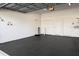 Spacious two-car garage with a durable, black-textured floor and overhead storage at 1024 Green Gate Blvd, Groveland, FL 34736
