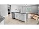 Modern kitchen island with stainless steel dishwasher and sink, leading to a living room with hardwood floors at 1024 Green Gate Blvd, Groveland, FL 34736