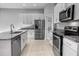 Modern kitchen with stainless steel appliances, white cabinets, and an island with a granite countertop at 1024 Green Gate Blvd, Groveland, FL 34736