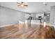 Open-concept living room featuring hardwood floors and seamless flow into a kitchen with white cabinets and stainless appliances at 1024 Green Gate Blvd, Groveland, FL 34736