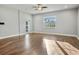 A large living room area features shiny hardwood floors, a ceiling fan, and views of the outdoors at 1024 Green Gate Blvd, Groveland, FL 34736