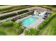 Aerial view of a community pool surrounded by lush landscaping and lounge seating at 1024 Green Gate Blvd, Groveland, FL 34736