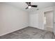 Bedroom with neutral walls, soft carpet, a ceiling fan, and double closet doors with a peek to the en suite bathroom at 103 White Horse Way, Groveland, FL 34736