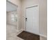 Bright foyer with neutral tile flooring and a white front door, creating a welcoming entrance to the home at 103 White Horse Way, Groveland, FL 34736