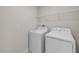 A laundry room featuring a modern white washer and dryer set with a wire shelf above for storage at 103 White Horse Way, Groveland, FL 34736