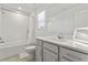 Modern bathroom with a shower, vanity and white tiling throughout at 11356 Sunsail Ave, Orlando, FL 32832