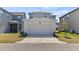 View of a two-car detached garage with driveway and landscaping at 11356 Sunsail Ave, Orlando, FL 32832