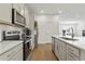 Bright kitchen boasts stainless appliances, white cabinets, stone backsplash, and modern lighting at 11356 Sunsail Ave, Orlando, FL 32832