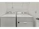 Laundry room with side-by-side white washer and dryer units and overhead storage at 11356 Sunsail Ave, Orlando, FL 32832