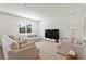 Bright living room with neutral furniture, large window, and a view of the neighborhood at 11356 Sunsail Ave, Orlando, FL 32832