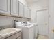 Laundry room with cabinets, wash sink, washer and dryer at 11537 Claymont Cir, Windermere, FL 34786