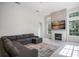 Cozy living room featuring a modern fireplace, wall-mounted TV, sectional couch and lots of natural light at 11537 Claymont Cir, Windermere, FL 34786