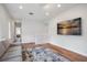 Open-concept living room featuring hardwood floors, a large TV, and a modern area rug at 11537 Claymont Cir, Windermere, FL 34786