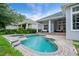 Backyard pool featuring a connected spa, stone coping, and a covered patio area at 11537 Claymont Cir, Windermere, FL 34786