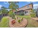 Landscaped backyard with a screened-in porch, rock beds, and flowering plants at 13067 Woodford St, Orlando, FL 32832