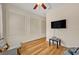 A clean bedroom design with a ceiling fan, vinyl flooring, and a large wall-mounted television at 13067 Woodford St, Orlando, FL 32832