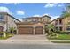 Elegant two-story home featuring a three-car garage and lush landscaping at 13067 Woodford St, Orlando, FL 32832