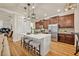 Bright kitchen with a white center island, stainless steel appliances, wood floors and elegant pendant lighting at 13067 Woodford St, Orlando, FL 32832