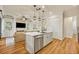 Bright kitchen features a white center island, stainless steel dishwasher and sink with a view into the living room at 13067 Woodford St, Orlando, FL 32832