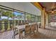 A screened patio with brick pavers showcases an outdoor dining area and comfortable seating for relaxation at 13067 Woodford St, Orlando, FL 32832