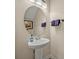 A pedestal sink and an oval mirror decorate this nicely appointed powder room at 13067 Woodford St, Orlando, FL 32832