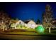 Beautiful one-story home boasting illuminated landscaping and manicured lawn at night at 14208 Bella Ln, Orlando, FL 32832