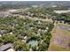 Expansive aerial view of a lush, wooded residential area with a tennis court and community amenities nearby at 144 E Plantation Blvd, Lake Mary, FL 32746