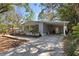 Inviting single-story home with covered carport and driveway, surrounded by mature trees at 144 E Plantation Blvd, Lake Mary, FL 32746