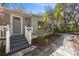 Inviting front porch and entry with stone walkway, complemented by lush, mature landscaping at 144 E Plantation Blvd, Lake Mary, FL 32746