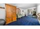Living room space featuring blue carpet, a large armoire, and access to the porch at 144 E Plantation Blvd, Lake Mary, FL 32746