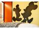 Fun bedroom featuring Mickey and Minnie Mouse silhouettes on bright yellow walls and a playful decor at 1445 Rolling Fairway Dr, Davenport, FL 33896