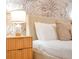 Cozy bedroom with bedside table, palm tree wallpaper, and a comfortable bed at 1445 Rolling Fairway Dr, Davenport, FL 33896