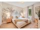 Serene bedroom with a queen-size bed, accent wall with palm tree design, and natural light at 1445 Rolling Fairway Dr, Davenport, FL 33896